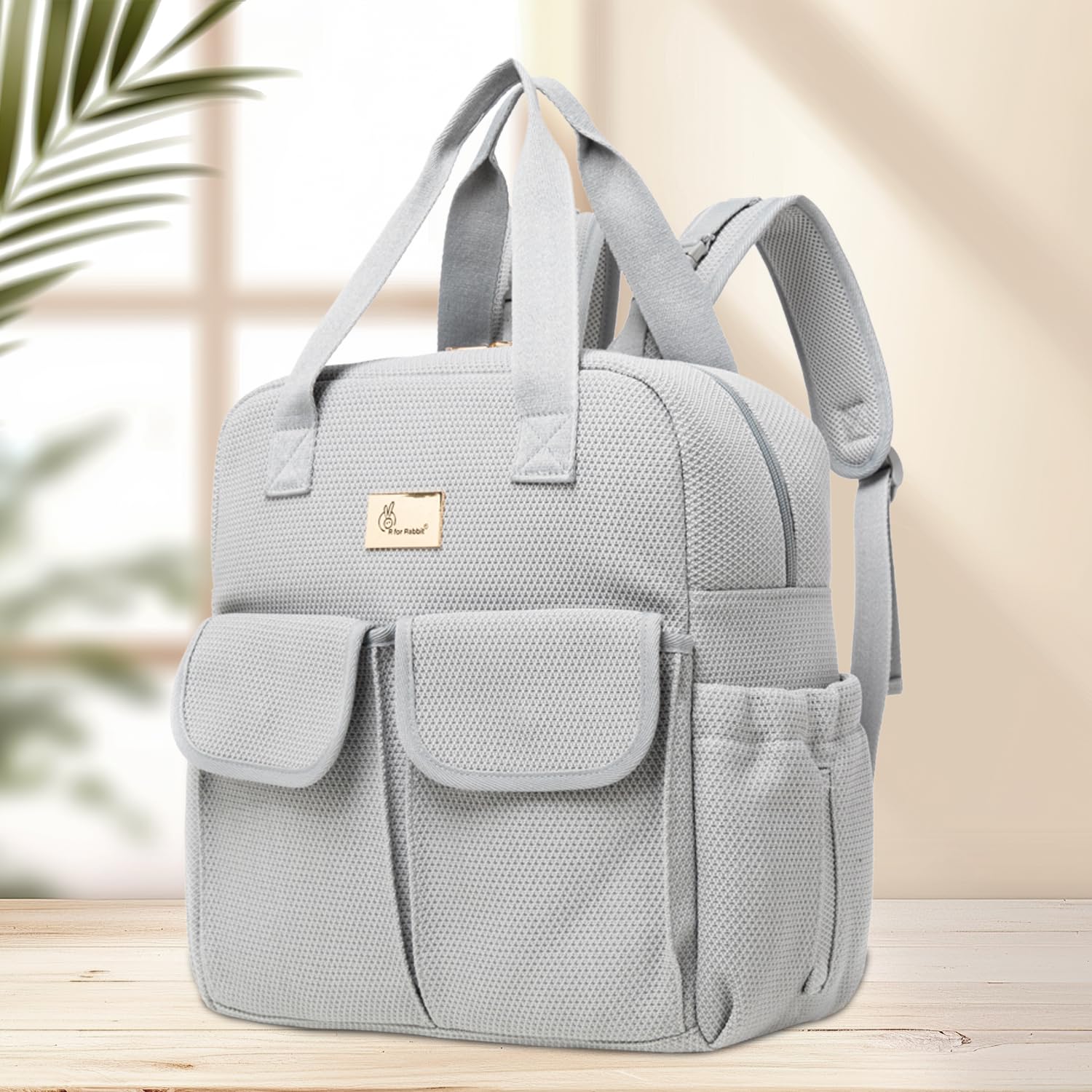 Gray backpack with a brand logo on a wooden surface with a blurred background